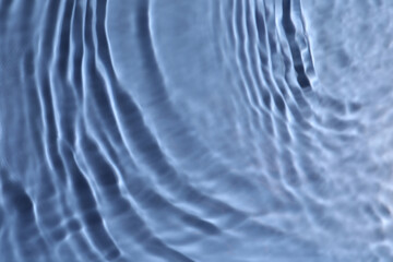 Closeup view of water with rippled surface on blue background