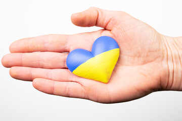 Heart flag of Ukraine in human hands. No war, peace for Ukraine concept.
