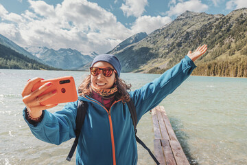 A female travel blogger takes a selfie on her phone for social networks against the background of a...