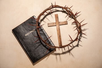 Crown of thorns with Holy Bible and cross on light background