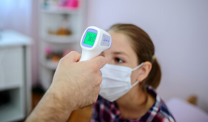 Father measuring temperature of his sick kid with thermometer, close up photo. Medical, health care concept