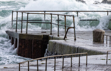 Huge storm waves coming through a pier safety barrier