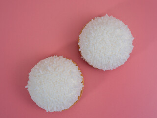 cake with coconut crumbs on a pink background.