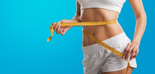 Concept diet. Woman measures her waistline with measuring tape. Healthy body shaping weight loss...