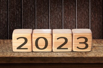 Flipping wooden cubes 2022 to 2023 with blue background. Happy new year 2023.