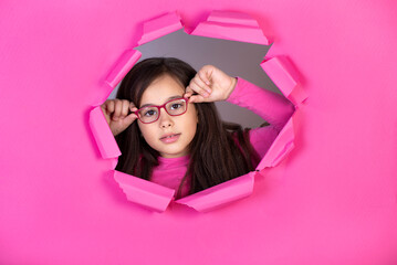 Funny child girl in glasses on colored background
