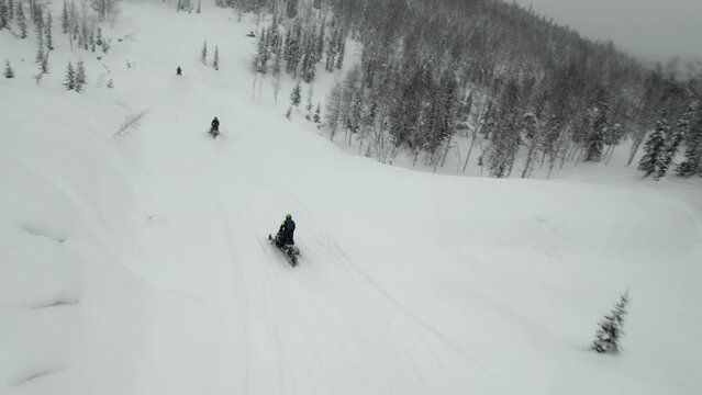Group descent from the mountain on snowmobiles