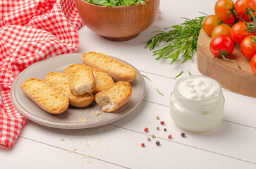 Vegetarian toasts with cream cheese tomatoes arugula rosemary and black pepper on rustic wooden table