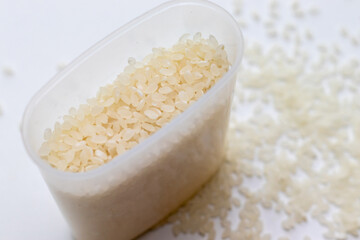 プラスチック製の計量カップと白い米粒