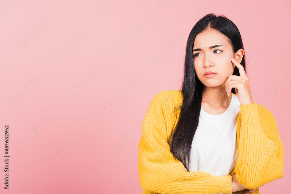 Wall mural Portrait Asian beautiful young woman standing chin handle relaxed thinking about something about the question studio shot isolated on pink background, Thai female idea think with copy space