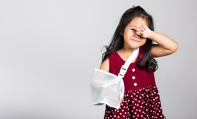Arm broken. Little cute kid girl 3-4 years old hand bone broken from accident with arm splint in studio shot isolated white background, Asian children preschool injured after accident, health concept
