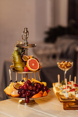 a plate of fruit stands on a wooden table covered for the holiday