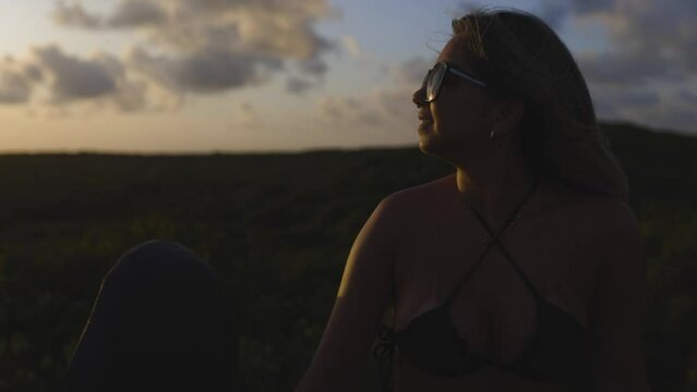 Latin woman watching the sunset in the dunes.