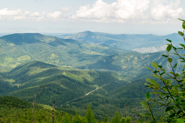 Obraz premium Summer landscape. Mountains covered with the shadow of clouds floating across the sky.