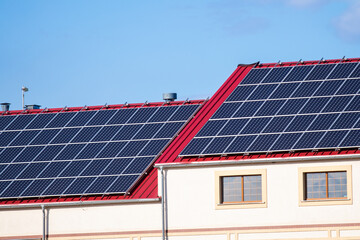 Naklejka premium photovoltaic panels on the red roof
