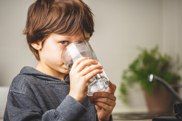 Kid drinking clean tap water at home