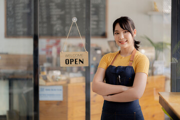 female receptionist in cafe shop with sign Open and close the shop, she is an employee of a cafe serving and serving customers who come to use the service in the shop. The concept of serving a cafe.