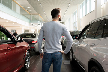 a man chooses a new car in a car dealership