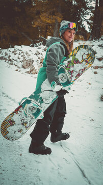 Mujer caucásica rubia de ojos azules esquiando con tabla de Snow en la montaña.