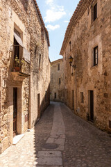 narrow stone street in the medieval town of pals on the costa brava on a sunny summer day