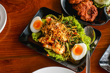 Thai style sweet and spicy water mimosa salad with shrimps and boiled egg