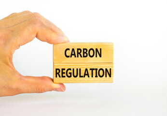 Carbon regulation symbol. Concept words Carbon regulation on wooden blocks on a beautiful white table white background. Businessman hand. Business and carbon regulation concept, copy space.