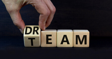 Dream team dreamteam symbol. Businessman turns wooden cubes and changes the word Dream to Team....