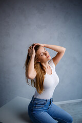 Close-up portrait of a young beautiful woman with blond hair of European appearance. Dressed in a white T-shirt. Emotional photo of a person