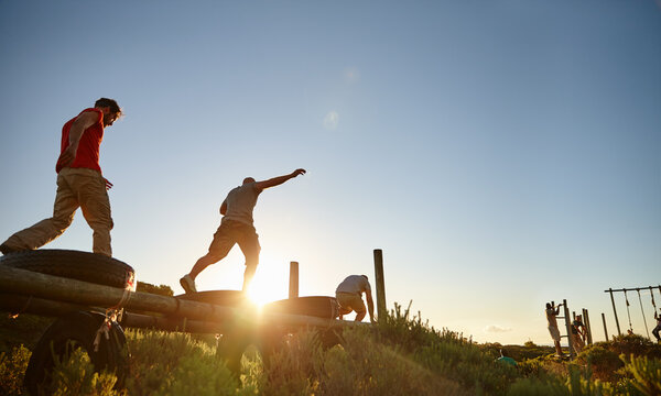 Putting in 100. Shot of a group of men going through an obstacle course at bootcamp.