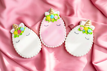 background banner greeting card for Happy Easter with colorful eggs gingerbread cookies in shape of unicorns on pink silk fabric background