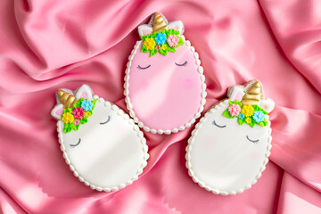background banner greeting card for Happy Easter with colorful eggs gingerbread cookies in shape of unicorns on pink silk fabric background