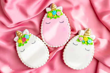 background banner greeting card for Happy Easter with colorful eggs gingerbread cookies in shape of unicorns on pink silk fabric background