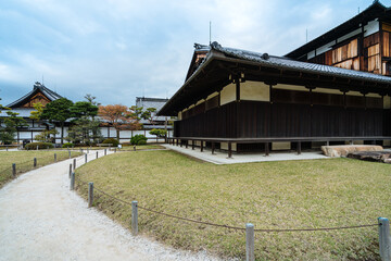view of curved path outside an ancient japanese religious building. picture of pathway winding along the lawn in front of a zen buddhist temple.