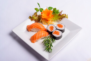Japanese food mix including sushi and sashimi on white plate.