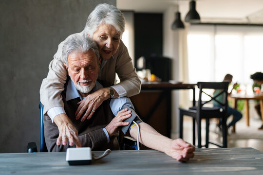 Senior couple measure each other's blood pressure. Concept of home health check
