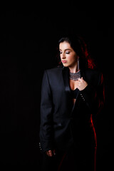 Obraz premium Portrait of a young beautiful woman with dark hair of European appearance. Dressed in a black jacket. Isolated on black background