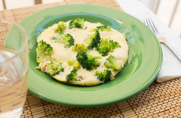 wholesome breakfast. omelet with broccoli on green plate