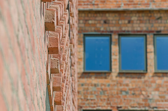 Fototapeta Ceglana elewacja z oknami / wystające cegły