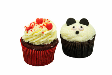 Two chocolate cupcakes with panda face cream shape and heart decoration on white background with copyspace