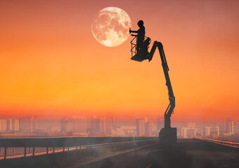 Silhouette of technician working on boom lift to the moon. © WITTAYA