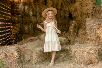 Romantic tween girl standing on hayloft during summer rural vacation