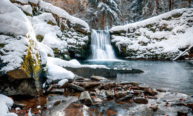 Scenic waterfall covered by snow during winter