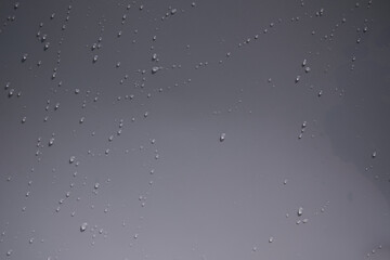 Close up of water drops on white tone background. Abstract white wet texture with bubbles on plastic PVC surface or grunge. Realistic pure water droplets condensed. Detail of canvas leather texture