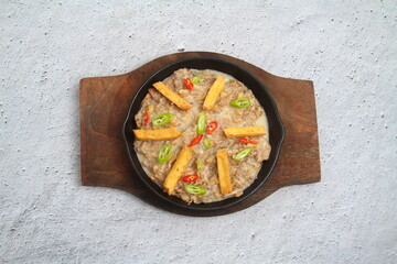Freshly made Filipino food called Pork Sisig or chopped pork served in a hot plate
