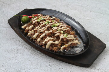 Freshly made Filipino food called Pork Sisig or chopped pork served in a hot plate