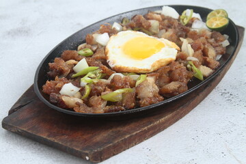 Freshly made Filipino food called Pork Sisig or chopped pork served in a hot plate