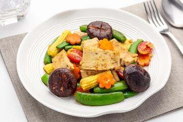Stir fried firm tofu with colorful vegetables like pea pods, shiitake mushrooms, carrot, cherry...