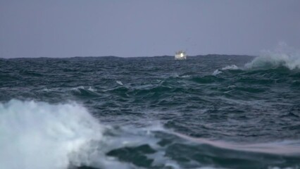 Small boat rocking in rough ocean waters in Iceland