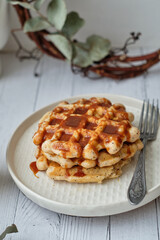 Waffles with caramel sauce. Wooden background. Top view. 
