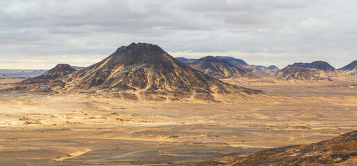 Fototapeta premium Volcanic mountains in Black Desert near the Bahariya Oasis in Egypt.